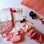 Tout le nécessaire pour s'occuper de sa poupée : porte-poupée, couche, chaussons, bloomer, etc.
